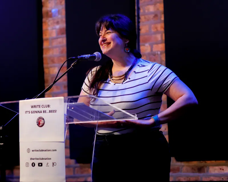 A combatant at the lectern, hand on hip, mid-sentence