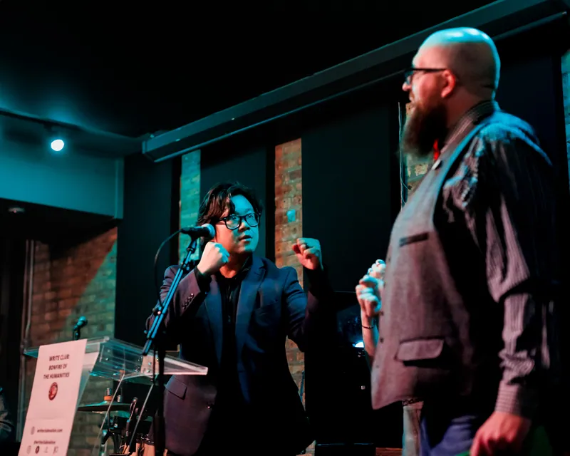 Two combatants facing each other at their microphones