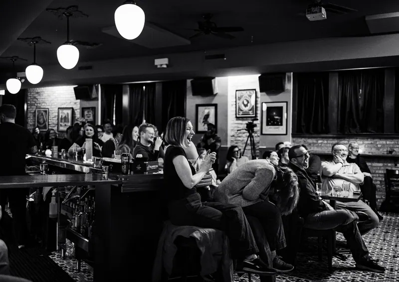 The bar and the seated crowd, in black and white