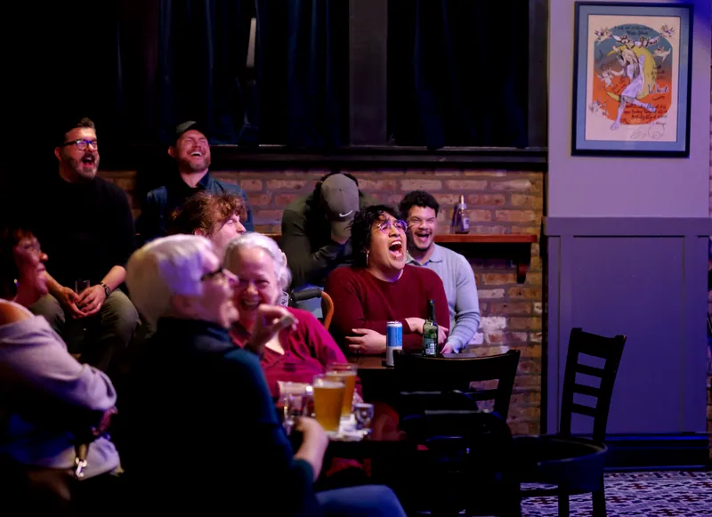 The crowd at the tables, mid-laugh